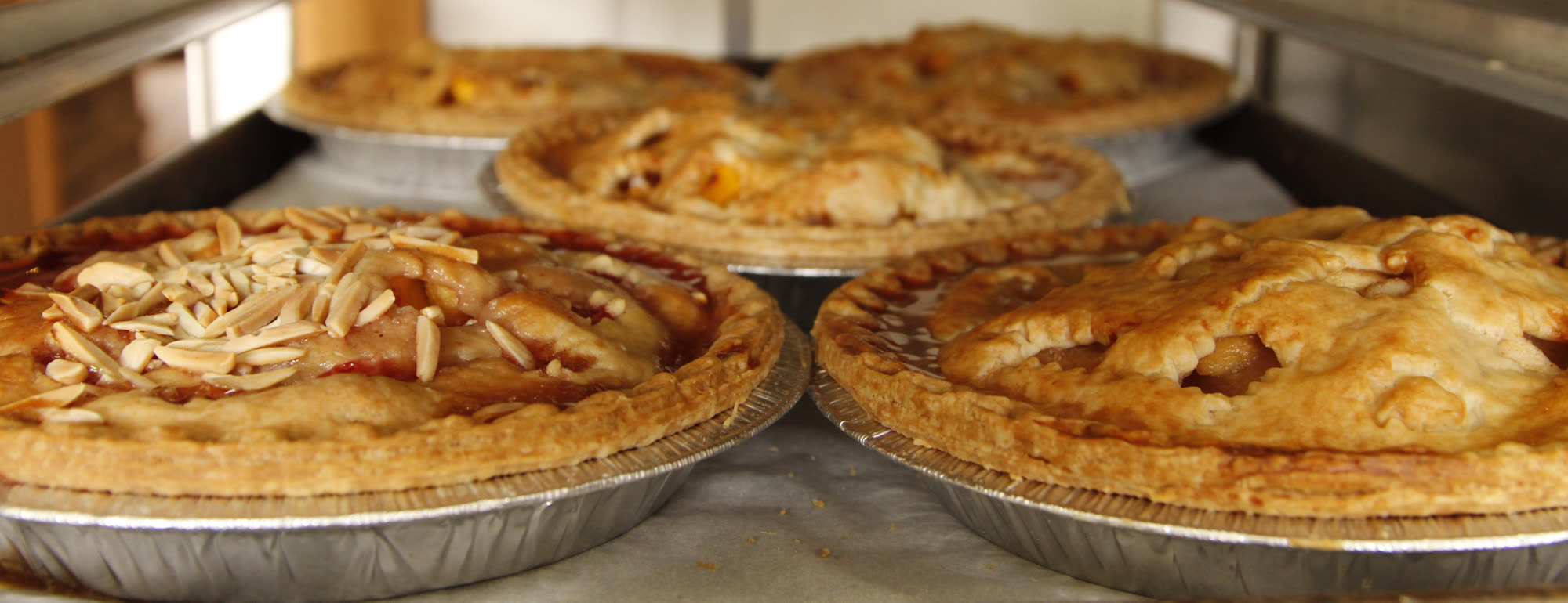 Fresh-baked fruit pies cooling on racks